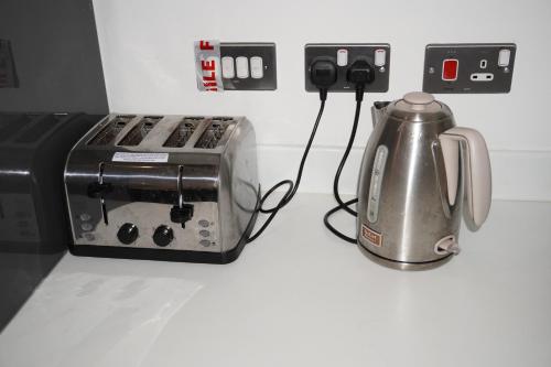 a toaster and a coffee maker on a counter at Luxury Rooms - Pick a Room - Free Parking & Kitchen Access, Near Etihad Stadium, The Coop Live & Piccadilly Station, Manchester in Manchester