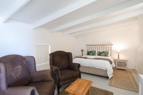 a living room with a bed and two chairs at Dreamcatcher Lavender in Paternoster