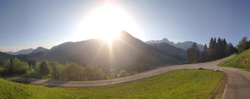 a road with the sun shining on a mountain at Buttermilchalm in Sankt Martin am Tennengebirge