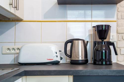a kitchen counter with a coffee maker and a toaster at Maison de ville proche Chenonceau Amboise 8 p in Bléré