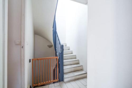 a stairway with a blue railing and a set of stairs at Maison de ville proche Chenonceau Amboise 8 p in Bléré