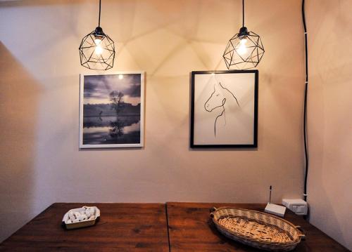 a room with two pictures and a wooden table at Vado al teatro monolocale in centro per 2 in Ancona