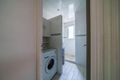 a white laundry room with a washing machine in it at Maison de ville proche Chenonceau Amboise 8 p in Bléré