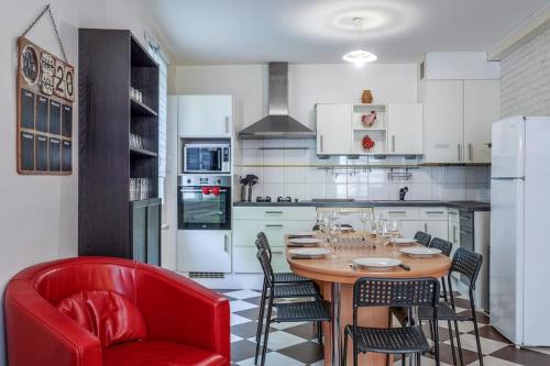 a kitchen with a wooden table and red chairs at Maison de ville proche Chenonceau Amboise 8 p in Bléré