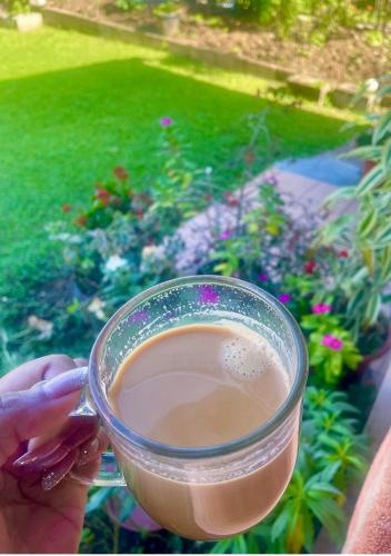 a person holding a cup of liquid in a window at Ida Homes in Suva