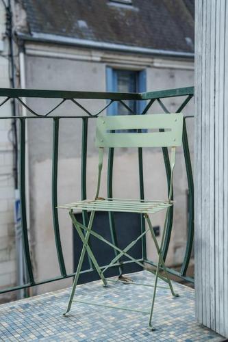a green chair sitting on top of a balcony at Maison de ville proche Chenonceau Amboise 8 p in Bléré