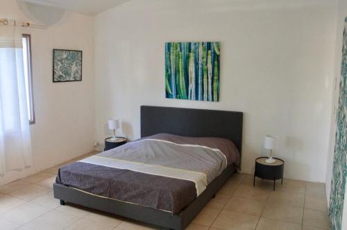 a bedroom with a bed and two lamps on tables at La Kaz Filaos in Saint-Paul