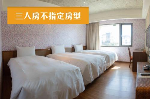 two beds in a hotel room with a sign above them at Jia Hsin Garden Hotel in Tainan