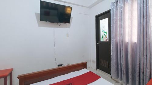 a bedroom with a bed and a television on the wall at RedDoorz near LRT 2 Antipolo Station in Antipolo