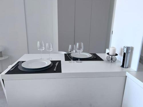 un comptoir blanc avec deux assiettes et des verres à vin dans l'établissement Amazing sea view, parking, easy beach access, à Cannes