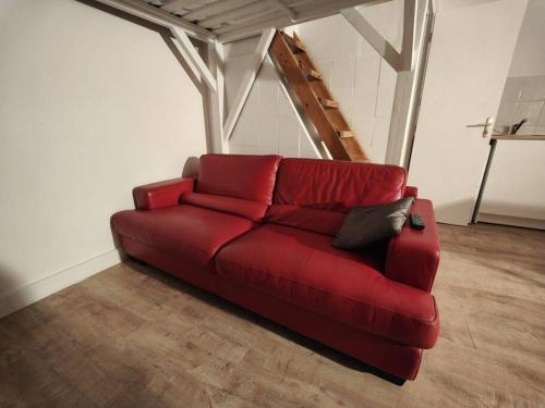 - un canapé rouge dans le salon dans l'établissement Studio rénové centre-ville Nîmes, à Nîmes