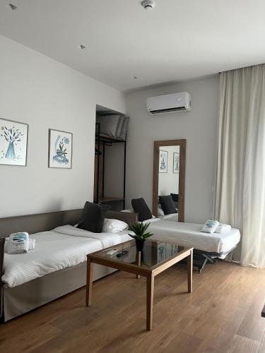 a living room with two beds and a coffee table at Maritime Suites in Hersonissos