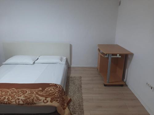 a bedroom with a bed and a wooden table at Nova Kuća na idiličnoj lokaciji sa mogućnosti korištenja pečenjare nije namijenjena malodobnoj djeci i osobama koje su osjetljive na miris dima in Šćapovec