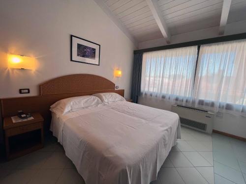 a bedroom with a large bed and a large window at Hotel Regina in Forte dei Marmi