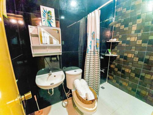 a bathroom with a sink and a toilet and a shower at Calm House near Enchanted Kingdom Sta Rosa with Free Parking, Wifi, Netflix in Santa Rosa