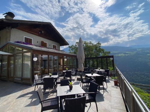 a restaurant with tables and chairs on a balcony at Sturmhof in Chiusa