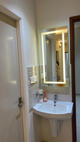 a bathroom with a white sink and a mirror at PENT HOUSE, Willows Apartments, Neermarga, Mangalore in Mangalore