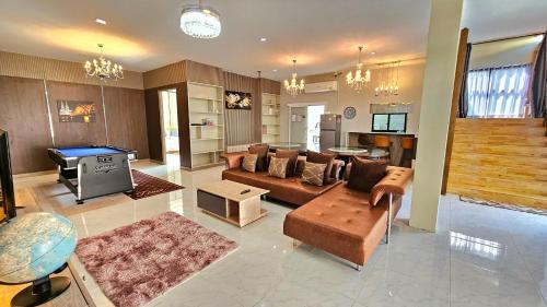 a living room with a couch and a pool table at PhuriPoolvilla ภูริพูลวิลล่า in Hang Dong