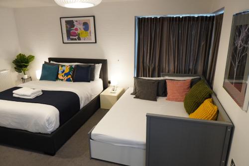 a bedroom with two beds and a window at Luxury Rooms - Pick a Room - Free Parking & Kitchen Access, Near Etihad Stadium, The Coop Live & Piccadilly Station, Manchester in Manchester