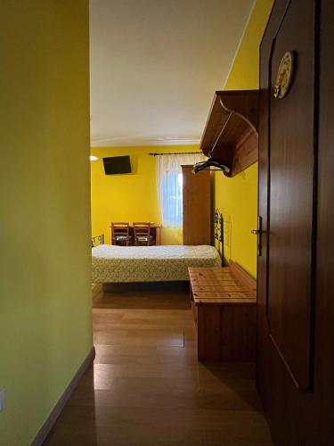 a bedroom with a bed in a yellow room at Corte Bussari in Arquà Polesine
