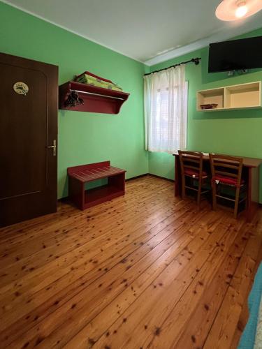 a living room with green walls and wooden floors at Corte Bussari in Arquà Polesine