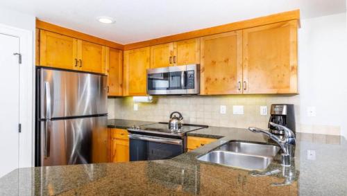 a kitchen with wooden cabinets and a stainless steel refrigerator at Marriott Timber Lodge 2BD Villa in Stateline