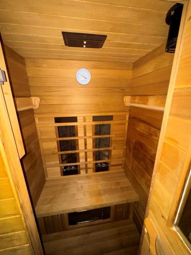 a small wooden sauna with a clock on the ceiling at Freundliche 2-Zimmer-Erdgeschosswohnung mit Garten in Seeberg in Sonntag
