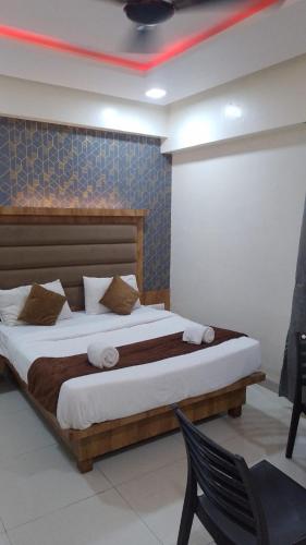 a bedroom with a bed and a chair in it at Sun Inn Residency Rabale in Navi Mumbai