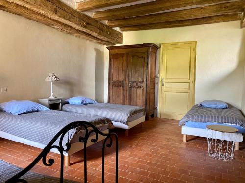 deux lits dans une chambre avec plafonds en bois dans l'établissement Manoir du Mont Porcher, à Saint-Symphorien