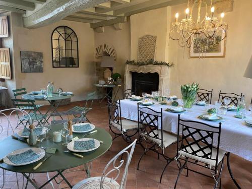 une salle à manger avec tables et chaises et une cheminée dans l'établissement Manoir du Mont Porcher, à Saint-Symphorien