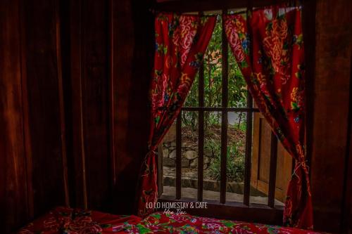 a room with a window with a red curtain at Lo Lo Homestay & Cafe Meo Vac in Mèo Vạc