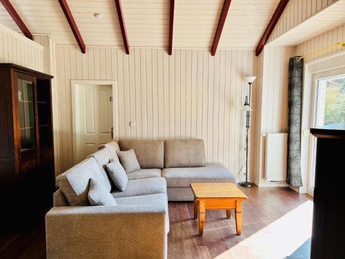 ハーレンにあるFerienhaus Bungalow Schloss Dankern, Emslandのソファとテーブルのあるリビングルーム