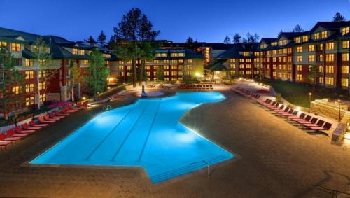 a large swimming pool in front of buildings at night at Marriott Timber Lodge Luxury Studio in Stateline