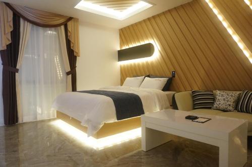 a hotel room with a bed and a couch at Noble Muintel in Suncheon