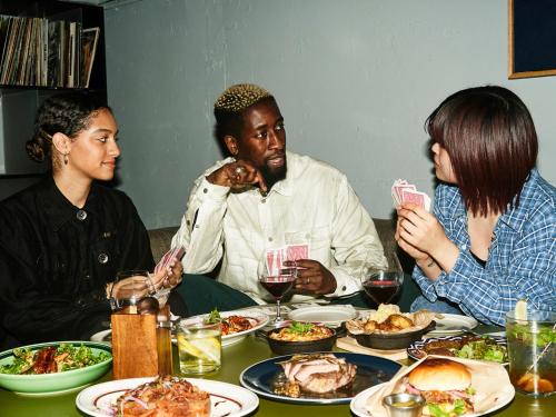 a group of people sitting around a table eating food at WPÜ HOTEL Shinjuku in Tokyo