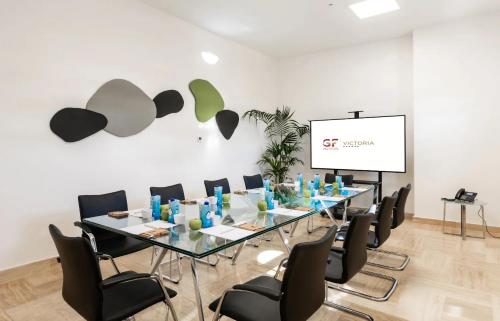 a conference room with a long glass table and chairs at GF Victoria in Adeje