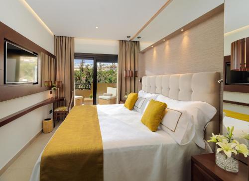 a bedroom with a large white bed with yellow pillows at GF Victoria in Adeje