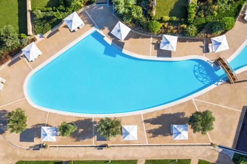 an overhead view of a swimming pool with umbrellas at Ikos Olivia in Gerakini