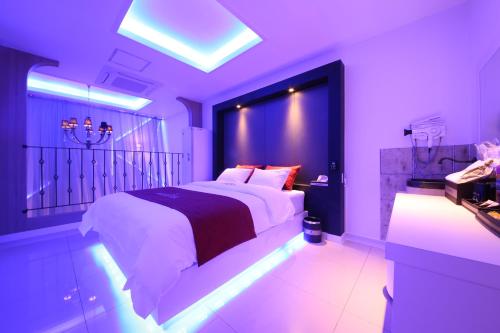 a purple bedroom with a large bed and a sink at Noble Muintel in Suncheon