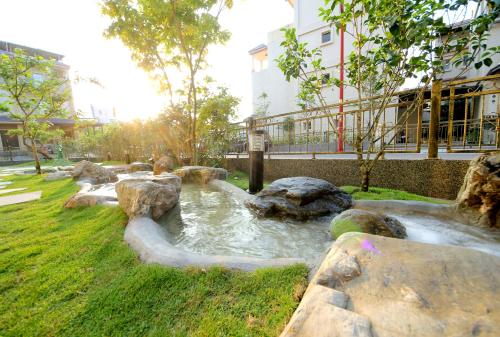a small pond with rocks in a park at Connecting Hearts in Dayin