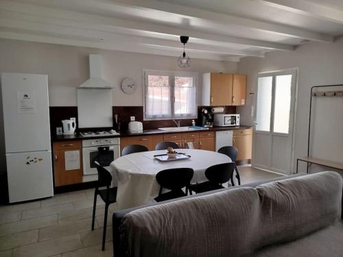 une cuisine avec une table et des chaises dans une pièce dans l'établissement Gite T3 