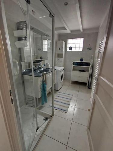 une salle de bain blanche avec une douche et un lavabo dans l'établissement Gite T3 