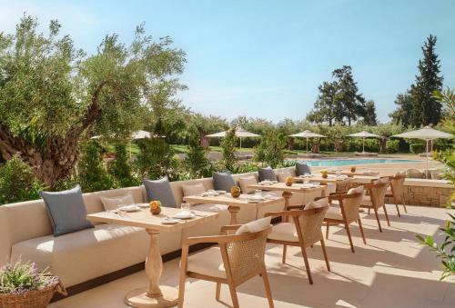 a row of tables and chairs next to a pool at Ikos Olivia in Gerakini