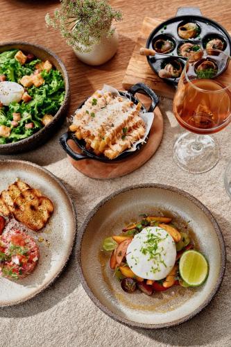 a table with plates of food and a drink at Ikos Olivia in Gerakini