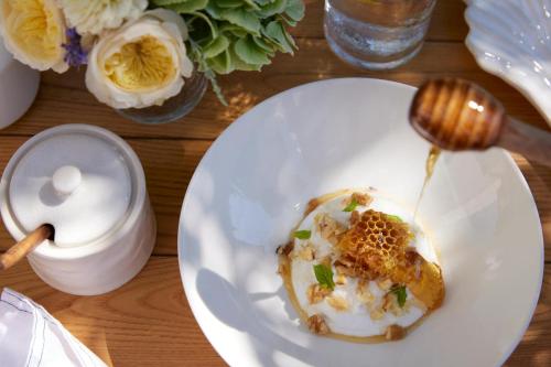 a white plate with food on a table at Ikos Olivia in Gerakini