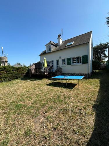 une maison avec une table de ping-pong dans la cour dans l'établissement Maison Bretonne vue mer 3 chambres 9 personnes 300m de la mer et du centre du Val André, à Pléneuf-Val-André