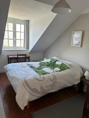 une chambre avec un lit avec une couette blanche dans l'établissement Maison Bretonne vue mer 3 chambres 9 personnes 300m de la mer et du centre du Val André, à Pléneuf-Val-André