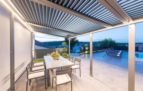 une pergola sur une terrasse avec une table et des chaises dans l'établissement 3 Bedroom Gorgeous Home In Sorici, à Šorići