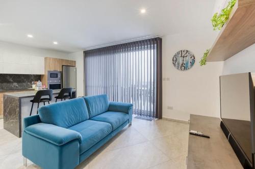 a blue couch in a living room with a kitchen at Lovely home with beautiful view with communal pool by 360 Estates in Taʼ Bullara