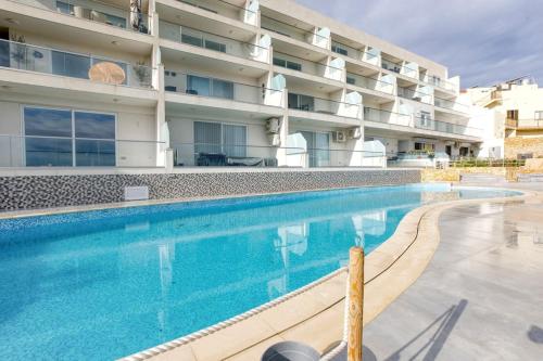 a swimming pool in front of a building at Lovely home with beautiful view with communal pool by 360 Estates in Taʼ Bullara